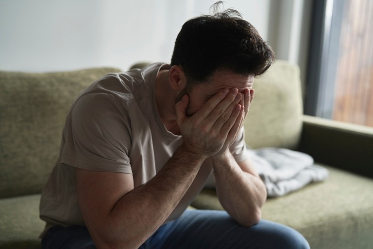 Distressed Man Sitting on Sofa