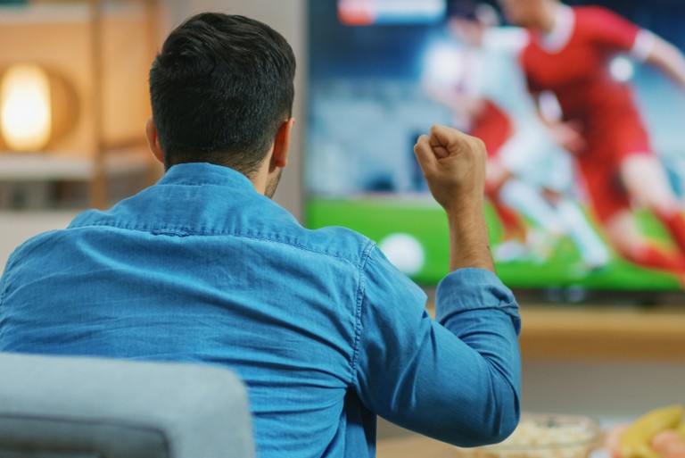 Man Cheering Watching Football on TV