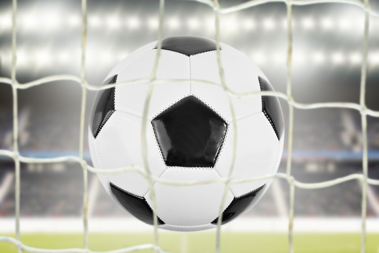 Football in Floodlit Stadium Through Net