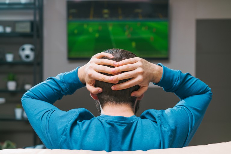 Man Watching Football with Hands on Head