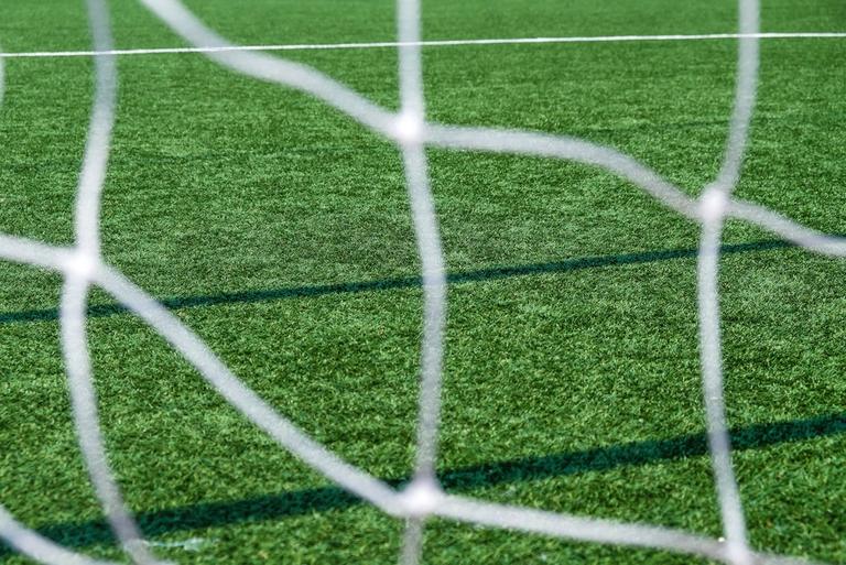 Sunny Football Pitch Through Goal Net
