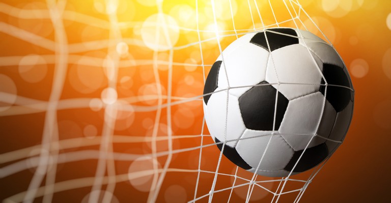 Football in Net Against Orange Light